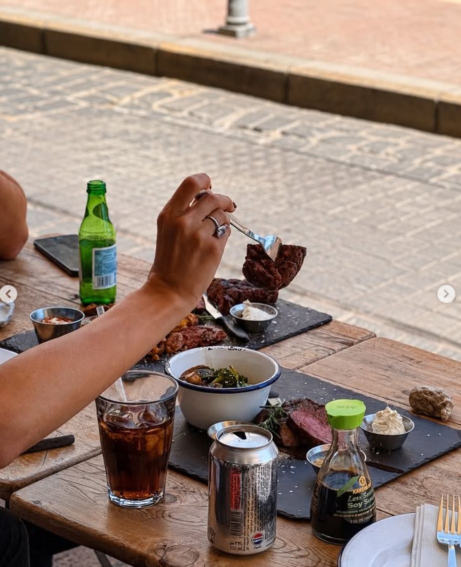 Sliced dry aged steak on slate boards at a terrace table